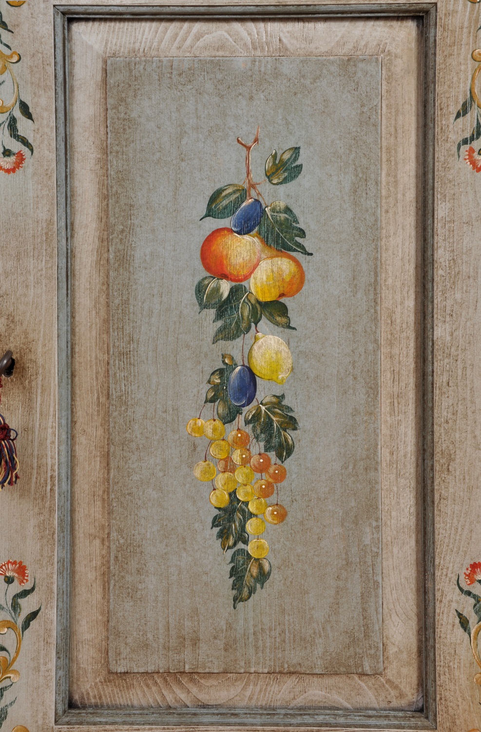 pregiata decorazione con frutta e soggetti vegetali dipinti a mano in policromia della credenza riprodotta a mano su misura in stile tirolese trentino per importanti case di montagna