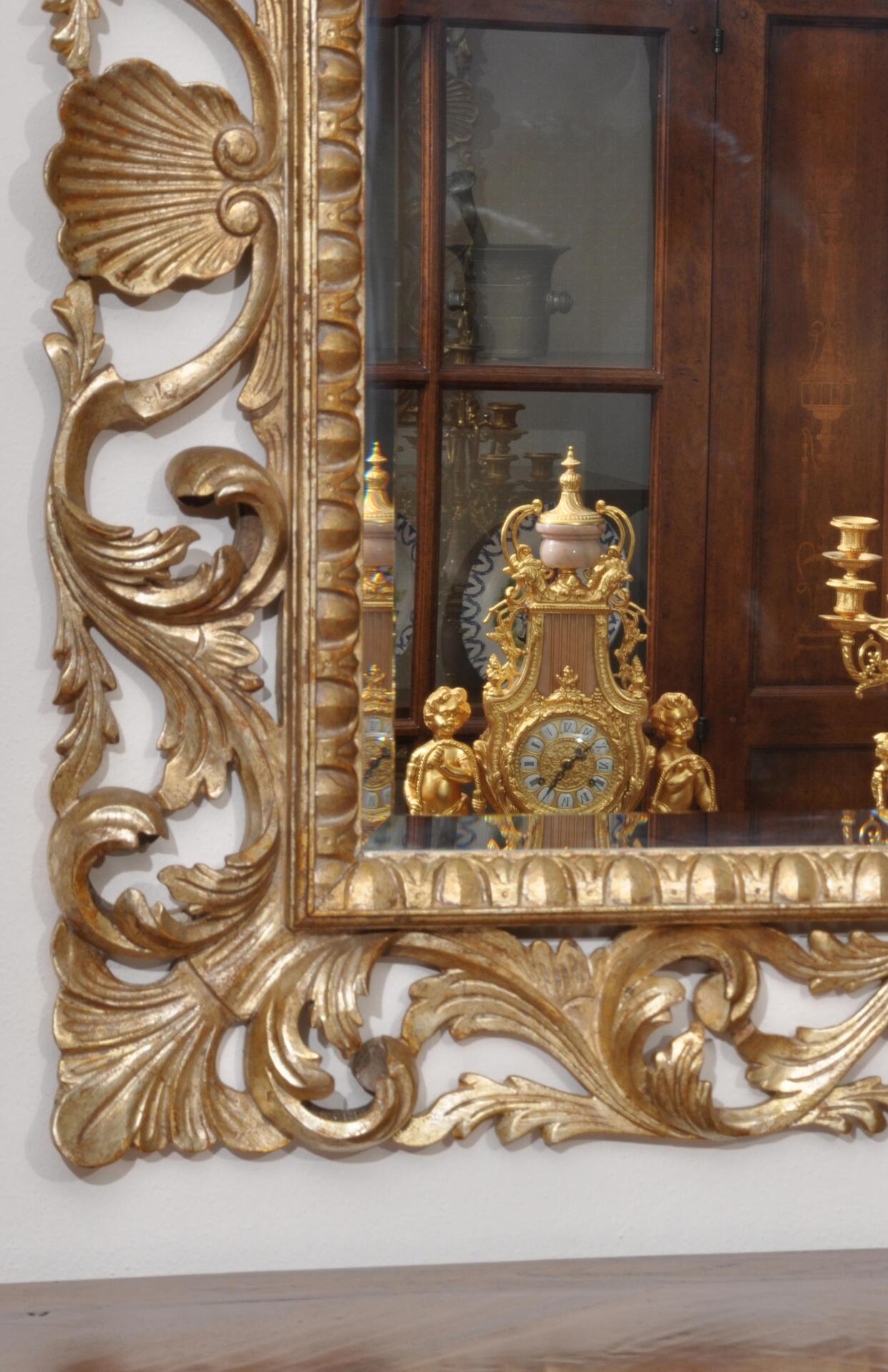 Elegante e pregiata specchiera veneziana di lusso con cornice dorata  scolpita a mano in stile barocco Luigi XV.