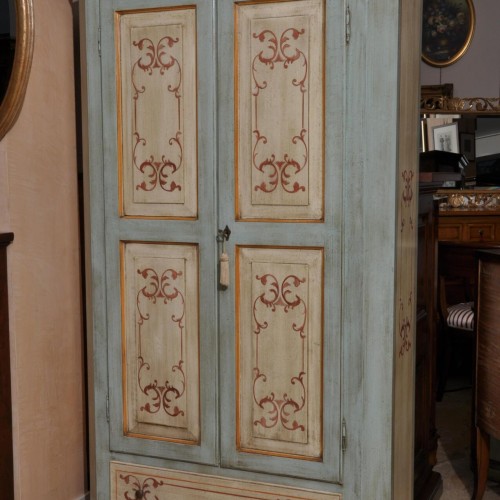 armadio in stile tirolese dipinto artigianalmente con laccatura e decorazioni fatte a mano color bianco panna e azzurro chiaro realizzabile su misura