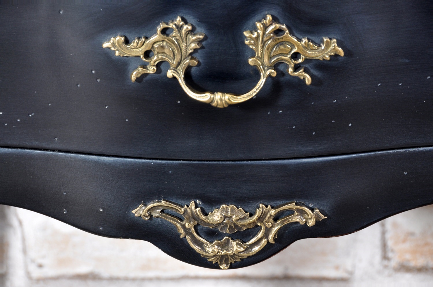 frontale del comodino arricchito da bronzi e laccato nero anticato fatto a mano
