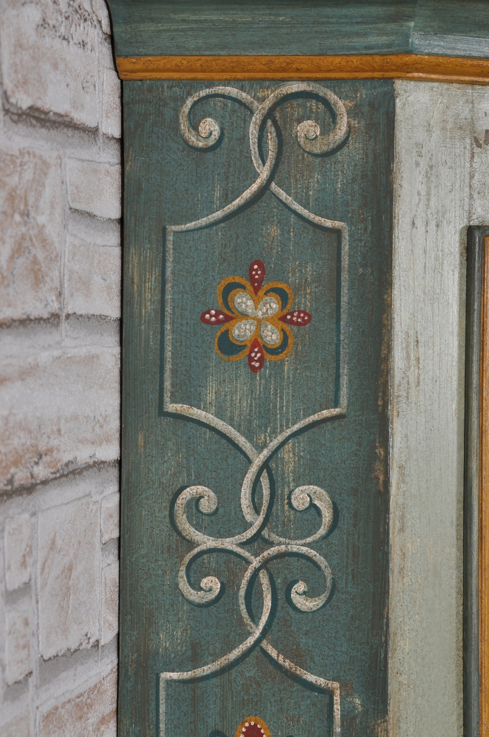 angolare dipinto a mano per lussuose case e residenze di montagna decorato con barocchi e fiori stilizzati in tonalità verde scuro su legno di abete massello