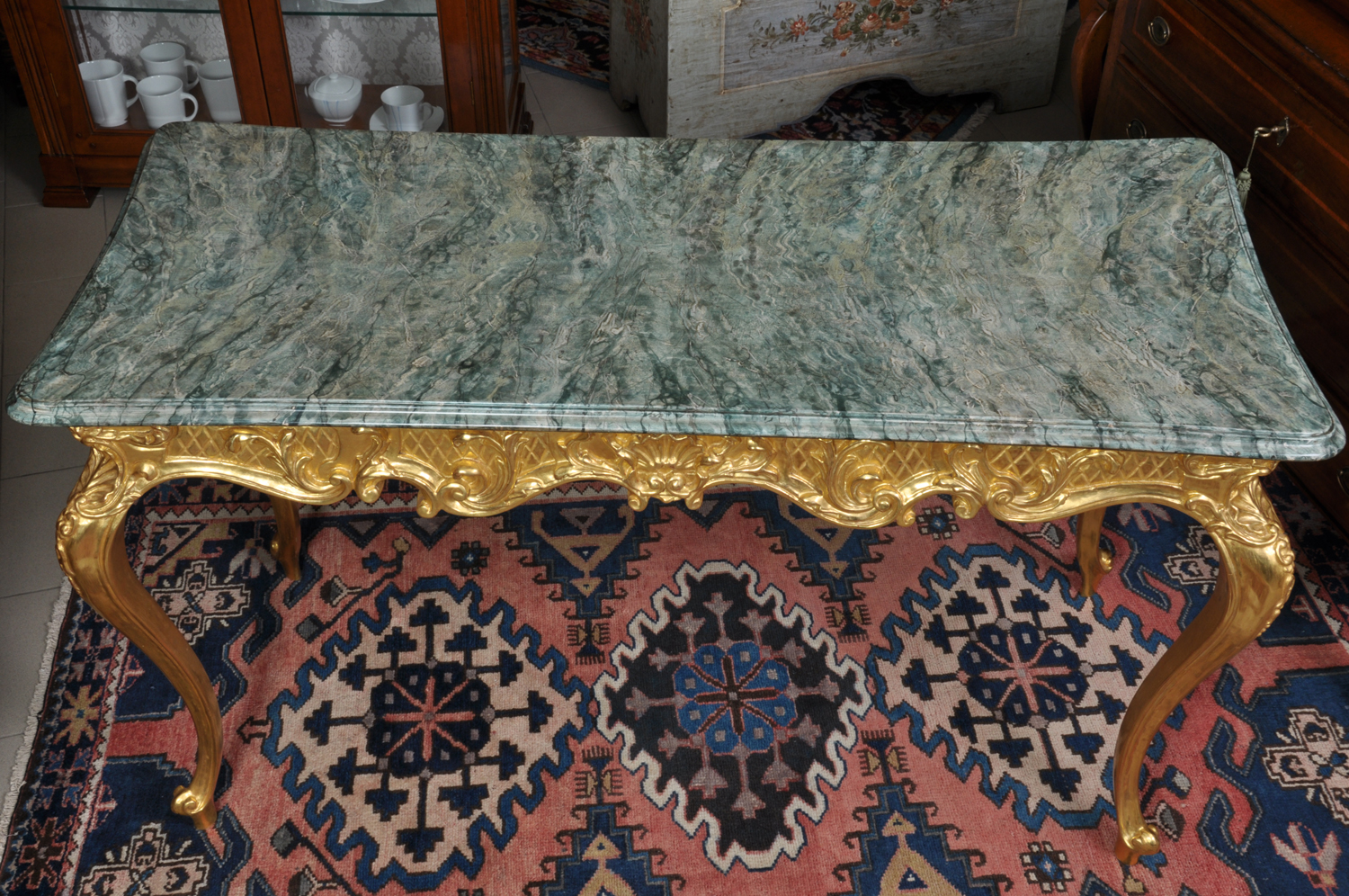 tavolo scrittoio prodotto dal brand di lusso Vangelista mobili 1960 in stile settecento veneziano, piano laccato in marmo verde alpi, fusto intagliato a mano in oro zecchino consumato, manufatto costruito su misura
